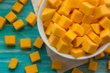 fresh pumpkin cut into pieces on wooden background, food