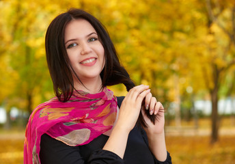 beautiful girl in black dress and red scarf in yellow city park, fall season