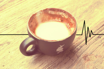 The drunk cup of coffee in vintage tone with the heart rate line. Concept of after drinking coffee, the heart rate will be alert.