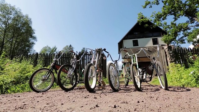 Six bicycles in front of open gates and big mansion in countryside. Summer day.