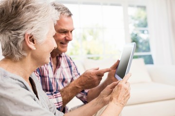 Smiling senior couple using tablet