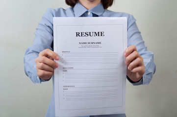 asian woman in work wear displaying resume information.