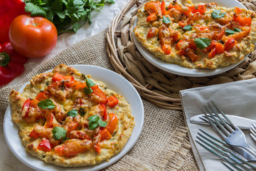 Pizza on the basis of chicken with tomatoes, peppers and cheese