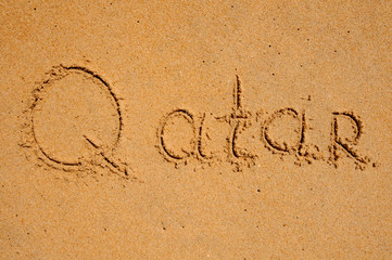 sign Qatar  written in the sand