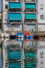 Fototapeta na wymiar Street view over channel with houses and reflections in Chioggia