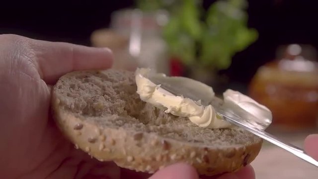 Close up spreading butter on bun slow motion male hand prores HQ
