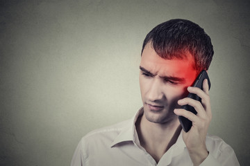 Man on the phone with headache. Cellular mobile radiation concept