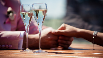 Couple, man and woman, drinking champagne in a fine dining restaurant, each with glass of sparkling wine in hand