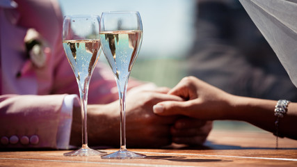 Couple, man and woman, drinking champagne in a fine dining restaurant, each with glass of sparkling...