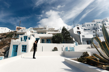 Handsome strong confident groom posing on roof with town in back