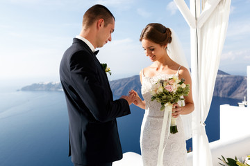 Happy groom and bride exchanging rings at aisle during ceremony