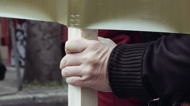 Hand of old woman holding sign in political protest