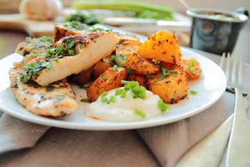 Grilled chicken breast fillet in herbs with garlic sauce and fried potatoes