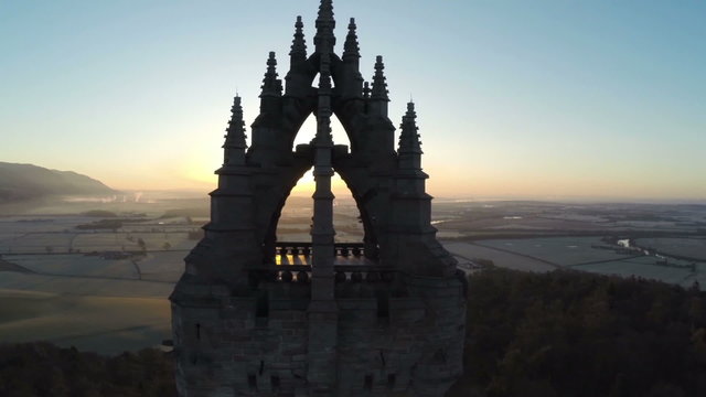 Aerial shot of the Wallace Monument in Scotland early on a summers morning with good light flare
