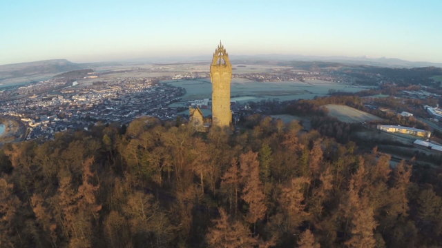 Aerial shot of the Wallace Monument in Scotland early on a summers morning with good light flare
