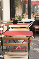 Fototapeta na wymiar colored tables and chairs outside a bistro in Paris