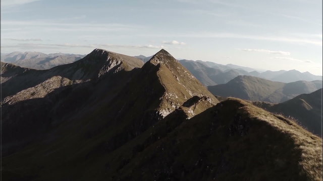 Spectacular aerial shot on Sgurr a'Mhaim mountain revealing devils ridge in the Scottish highlands during sunset
