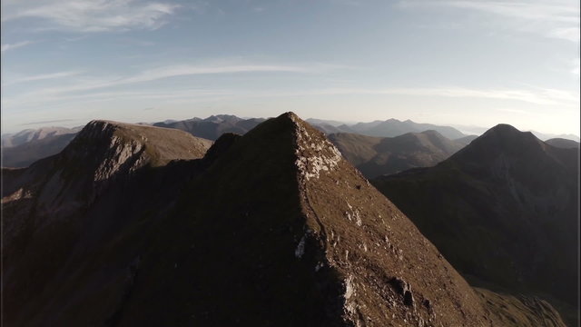 Spectacular aerial shot on Sgurr a'Mhaim mountain revealing devils ridge in the Scottish highlands during sunset

