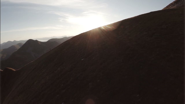 Spectacular aerial shot on Sgurr a'Mhaim mountain revealing devils ridge in the Scottish highlands during sunset
