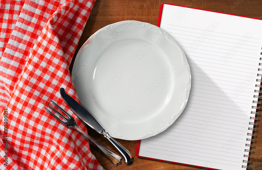 Poster notebook plate and cutlery / empty plate with silver cutlery and open notebook for recipes or food m