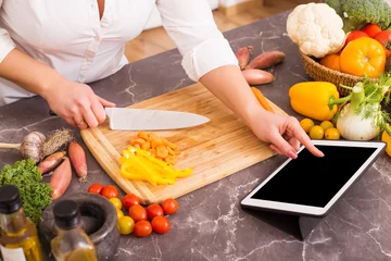 Foto op Plexiglas Koken Vrouw die tablet gebruikt om te koken