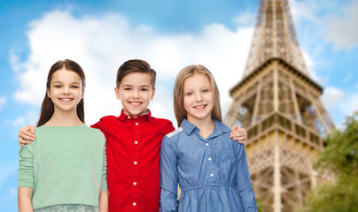 happy boy and girls hugging over eiffel tower