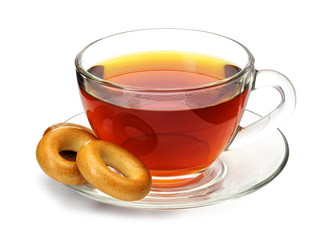 Cup of black tea with small bagels on a plate isolated on white background.