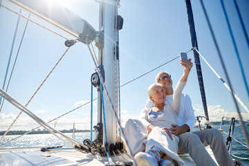 seniors with smartphone taking selfie on yacht