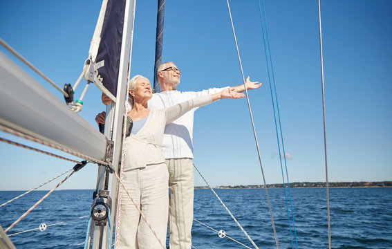 senior couple enjoying freedom on sail boat in sea