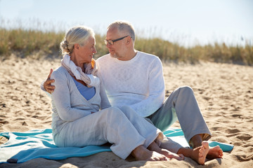 happy senior couple hugging on summer beach