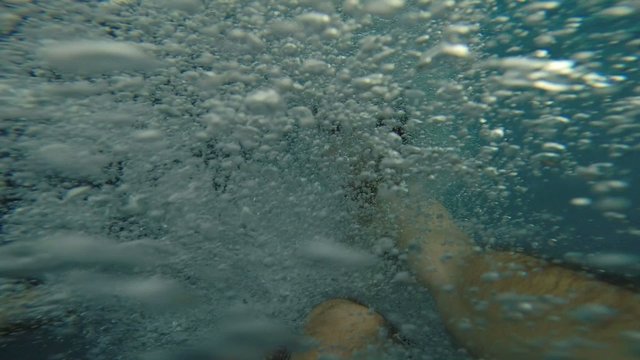 Man filming himself while jumping in swimming-pool