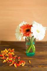 flowers in a vase on wooden background
