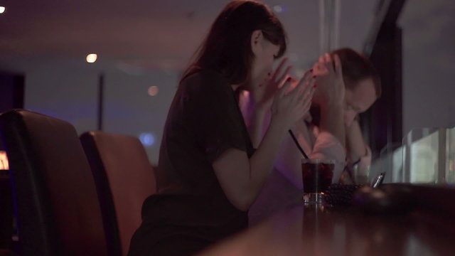 Young couple fighting, arguing in bar at night
