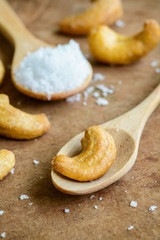 Salted and roasted cashew nuts on wooden table