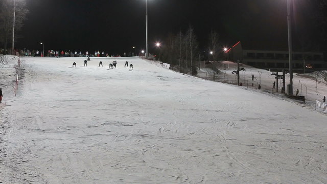 Skiers and snowboarders at night.Skiers and snowboarders skiing downhill in the winter season.Skiers and snowboarders enjoying on slopes of ski resort.night Scene