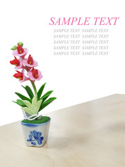 Isolated Plastic Flower on Wood Table with White Background and Sample Text