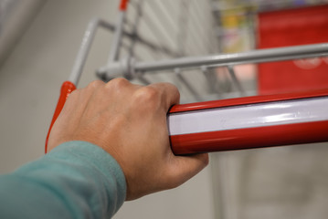 Closeup on hand with shopping cart 