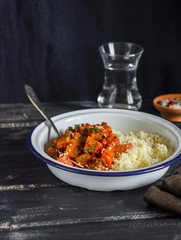 Pumpkin curry and cous cous on a dark wooden background.  Delicious vegetarian lunch