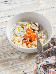 Oatmeal with baked sweet potatoes, honey and pecans. Delicious and healthy breakfast. On light wooden background