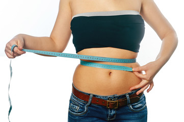 Young girl measuring waist with a white background
