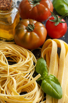 Fresh pasta and ingredients on a dark board