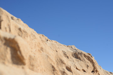 Fototapeta na wymiar Desert, sandy ground over background of blue sky 