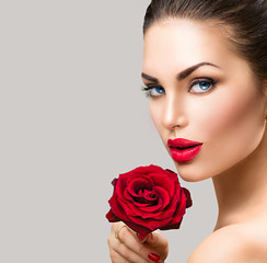 Fototapeta na wymiar Beauty fashion model woman face. Portrait with red rose flower