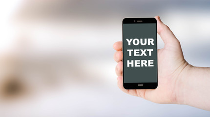 mobile phone with your text here on user´s hand