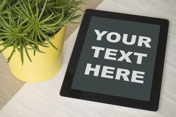 Tablet over a table with plant