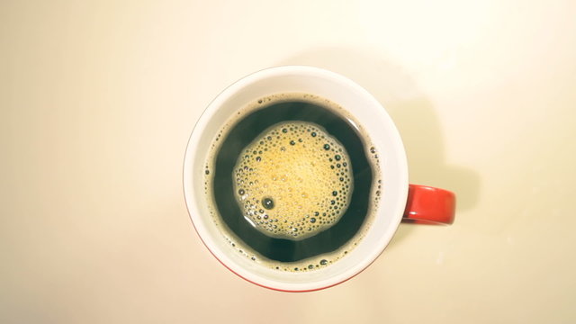 Cup of coffee on wooden table, top view
