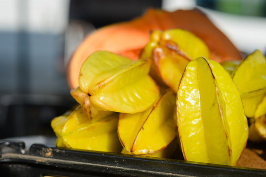 A box of starfruits on a market stall background
