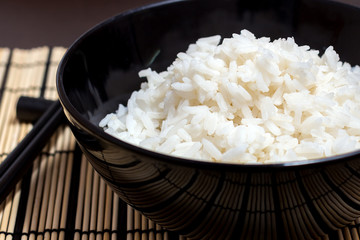 Сooked steamed rice in a black plate