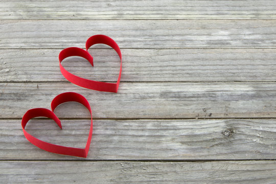 Two red hearts on wood background