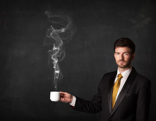Businessman holding a white steamy cup